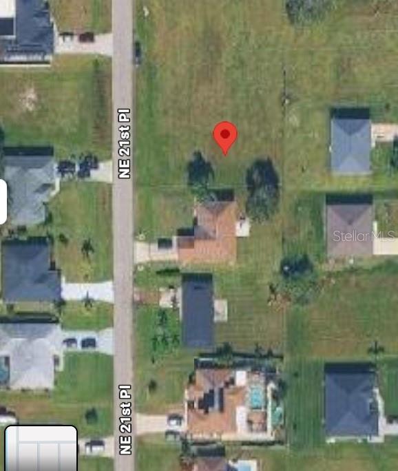 This is an aerial map view showing a residential lot with a red location pin — 1415 NE 21ST PLACE, CAPE CORAL, FL