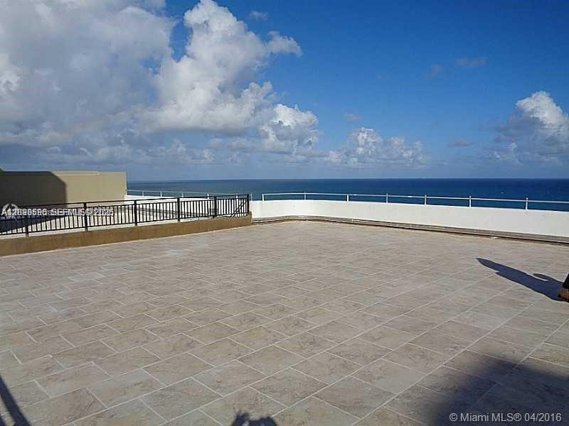 A tiled rooftop terrace overlooks the ocean with a black metal railing — 5555 Collins ave # 9V, Miami Beach FL 33140, MIAMI BEACH, FL