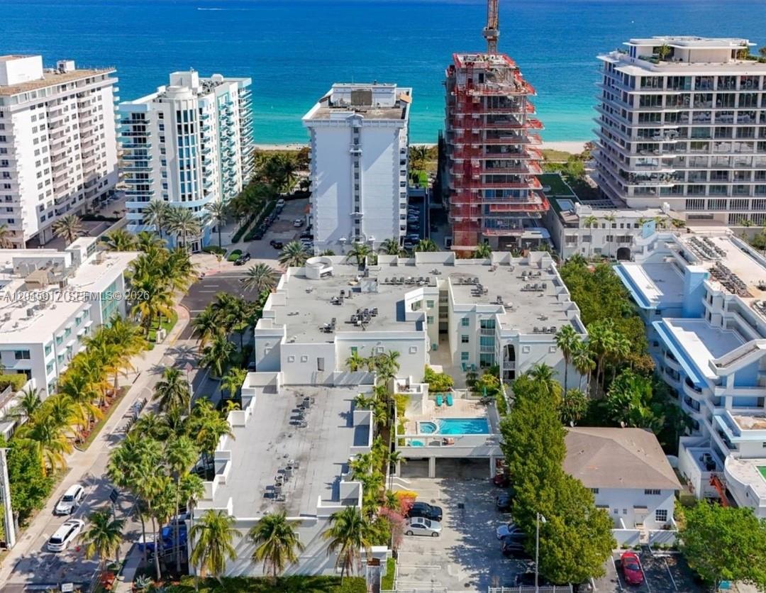 An aerial view shows a multi-story apartment complex with a pool and surrounding coastal buildings — 9172 Collins Ave # 218, Surfside FL 33154, SURFSIDE, FL