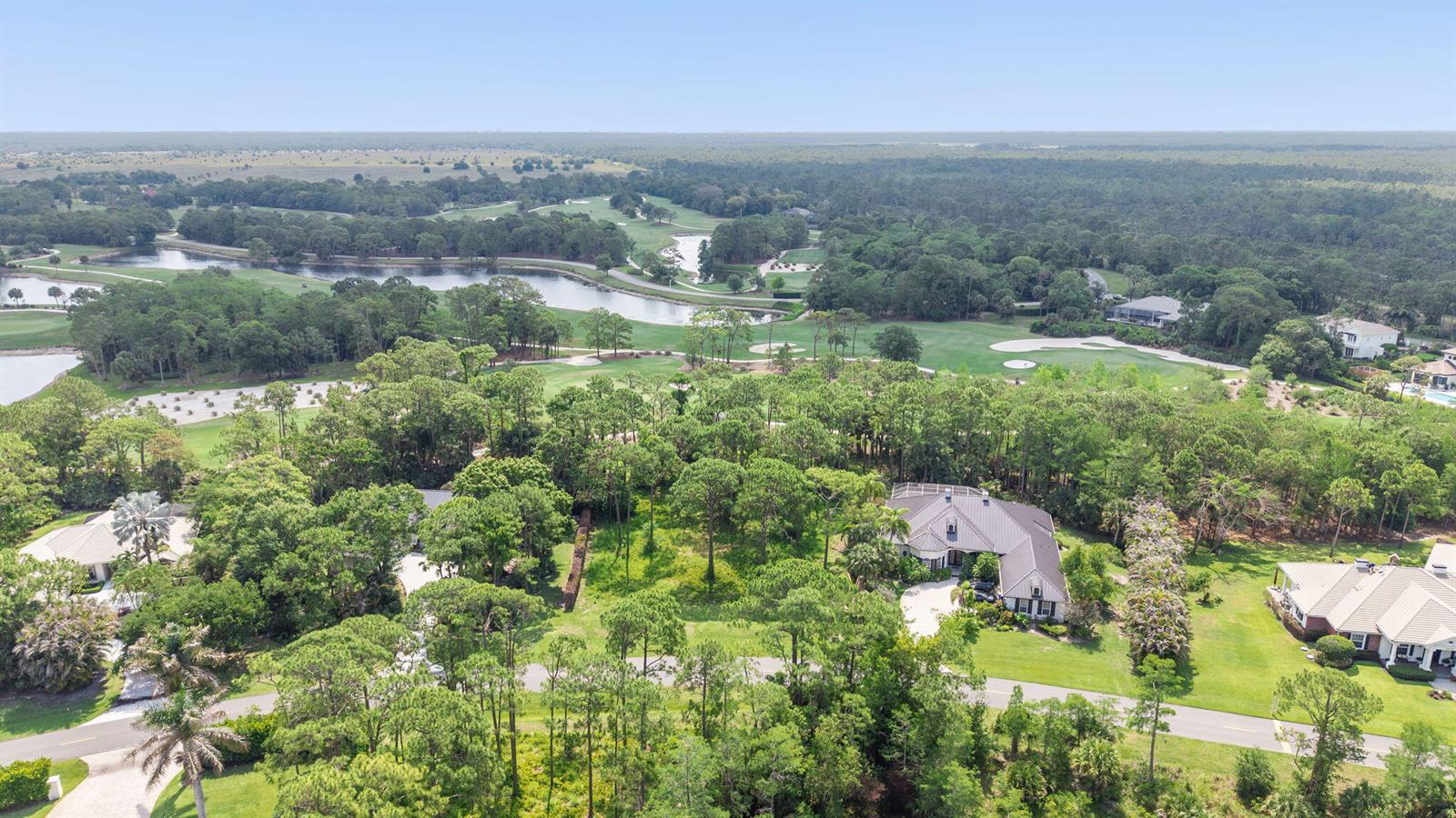 An aerial view shows a large house surrounded by trees, lawns, and a golf course — 19051 SE Old Trail Drive W, Jupiter FL 33478, JUPITER, FL
