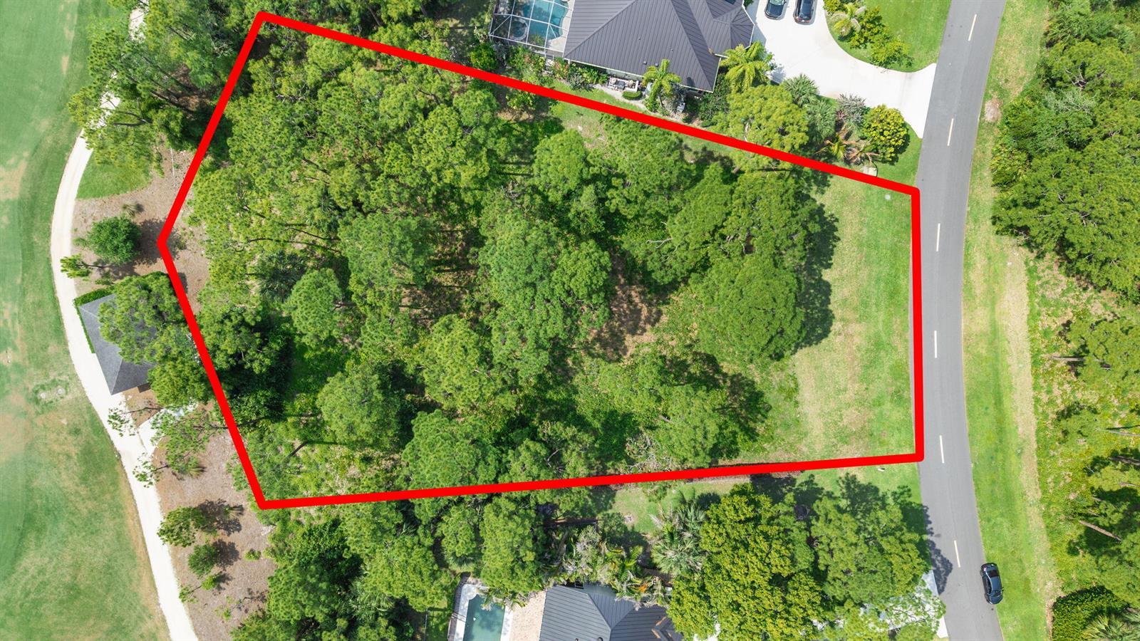 An aerial view shows a wooded, irregularly shaped vacant lot outlined in red — 19051 SE Old Trail Drive W, Jupiter FL 33478, JUPITER, FL