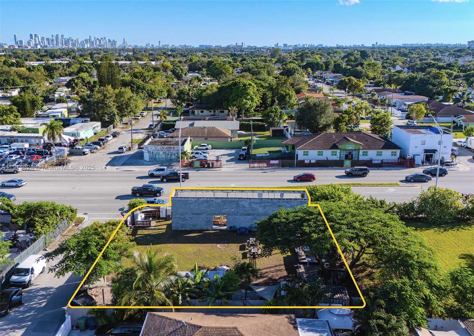 An aerial view shows a vacant lot with a concrete block structure and mature trees — 1441 NW 79th Street, Miami FL 33147, MIAMI, FL