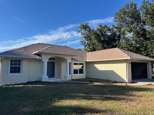 A single-story house with a beige exterior, a shingled roof, and a two-car garage — 2447 JARVIS STREET, NORTH PORT, FL