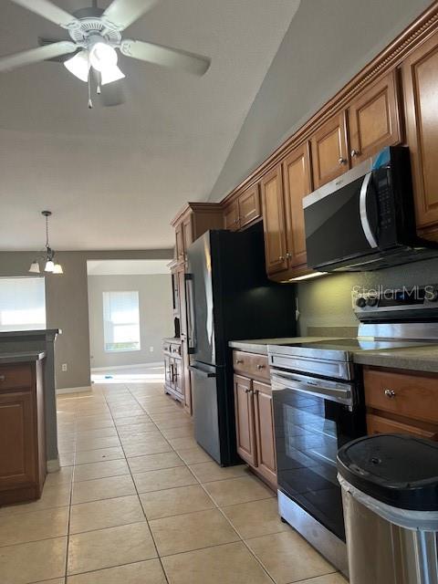 A kitchen features wood cabinets, a black refrigerator, a microwave, and tile flooring — 2447 JARVIS STREET, NORTH PORT, FL
