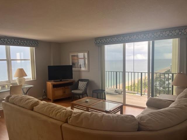 A living room with a sectional sofa, television, and a balcony overlooking the ocean — 101 Briny Avenue # 2402, Pompano Beach FL 33062, POMPANO BEACH, FL