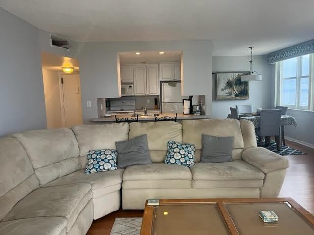 A living room with a large beige sectional sofa faces a kitchen and dining area — 101 Briny Avenue # 2402, Pompano Beach FL 33062, POMPANO BEACH, FL
