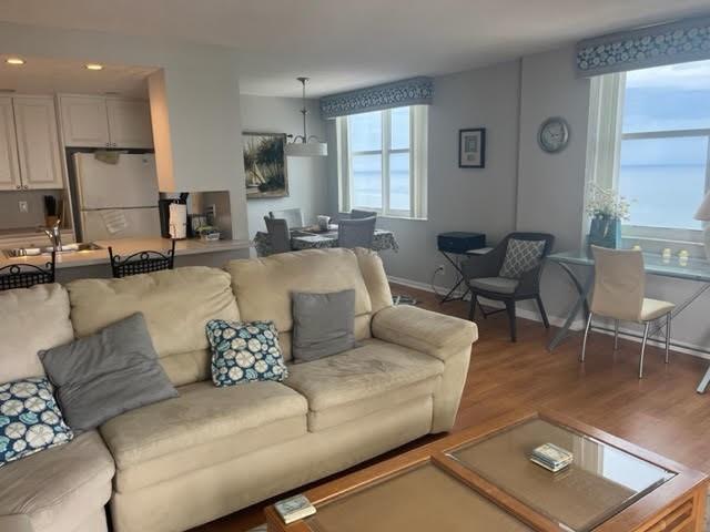 A living room features a beige sofa, a coffee table, and a dining area with windows — 101 Briny Avenue # 2402, Pompano Beach FL 33062, POMPANO BEACH, FL