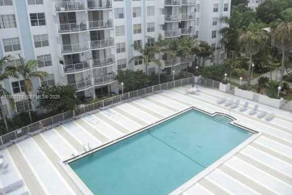 An aerial view of a rectangular swimming pool surrounded by a paved deck and building — 494 NW 165th St Rd # 602, Miami FL 33169, MIAMI, FL