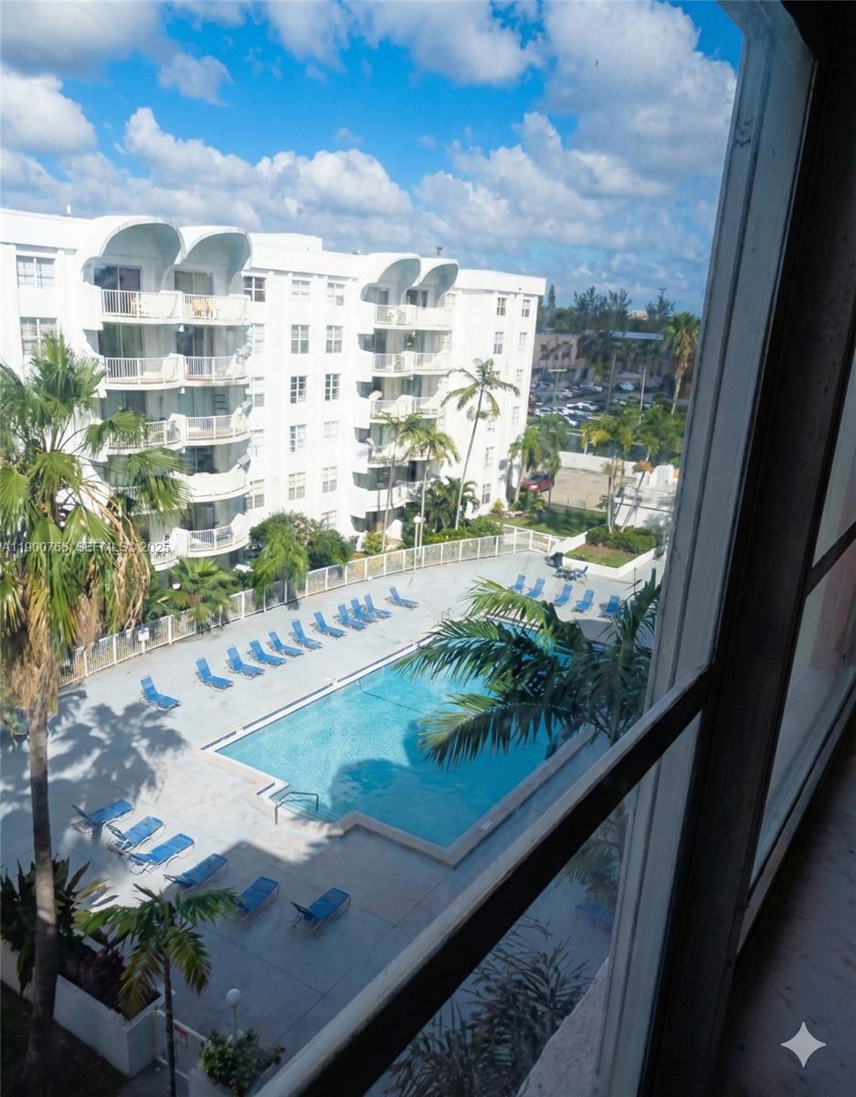An elevated view of a swimming pool and lounge chairs surrounded by apartment buildings — 494 NW 165th St Rd # 602, Miami FL 33169, MIAMI, FL