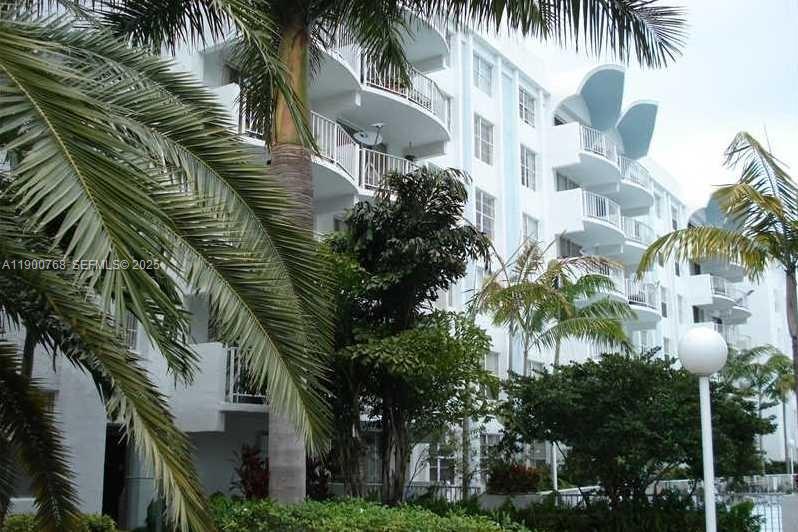 A multi-story white apartment building features curved balconies and is surrounded by palm trees — 494 NW 165th St Rd # 602, Miami FL 33169, MIAMI, FL