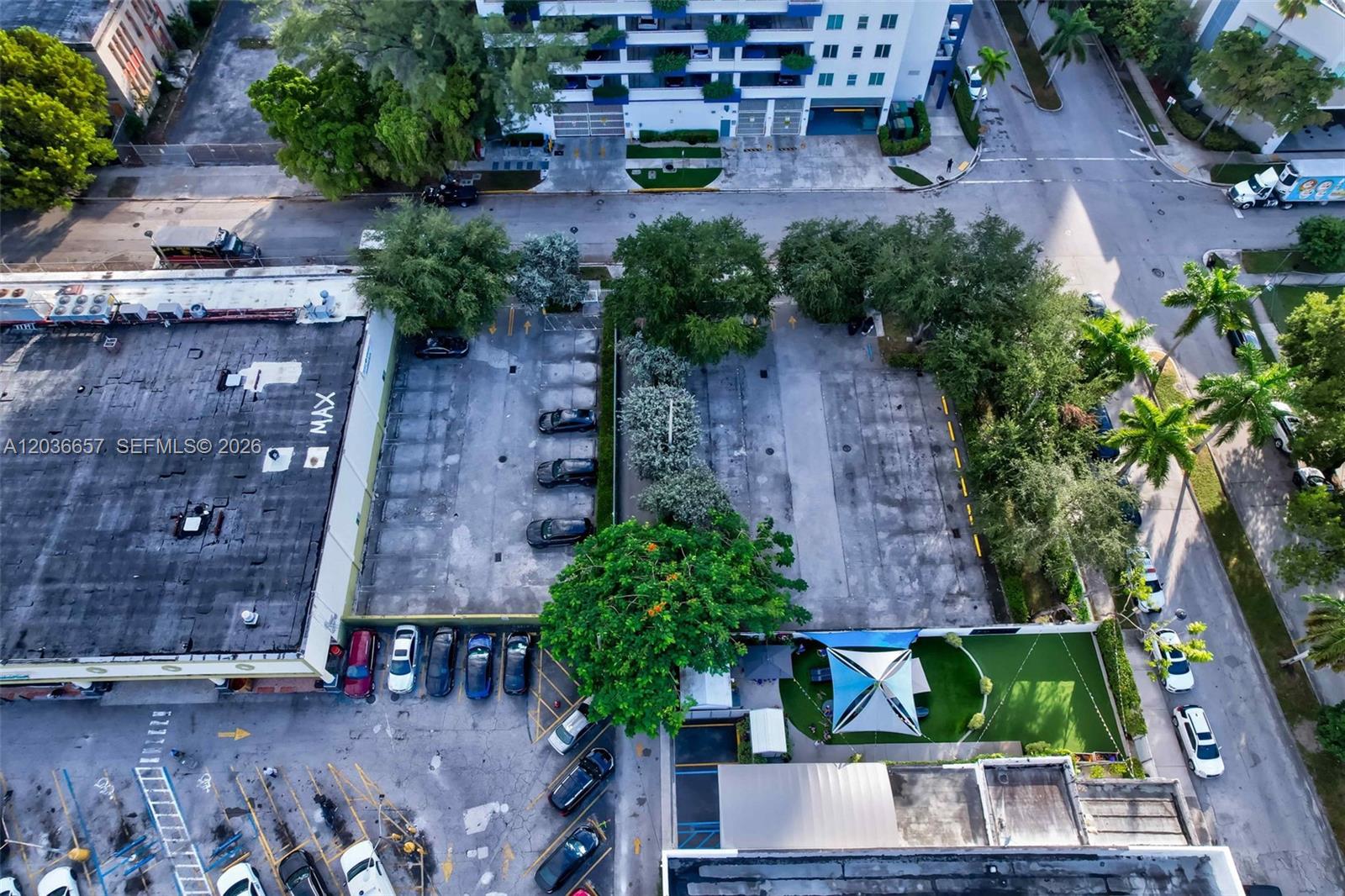 An aerial view shows a paved parking lot situated between commercial buildings and urban streets — 275 NE 18th St, Miami FL 33132, MIAMI, FL