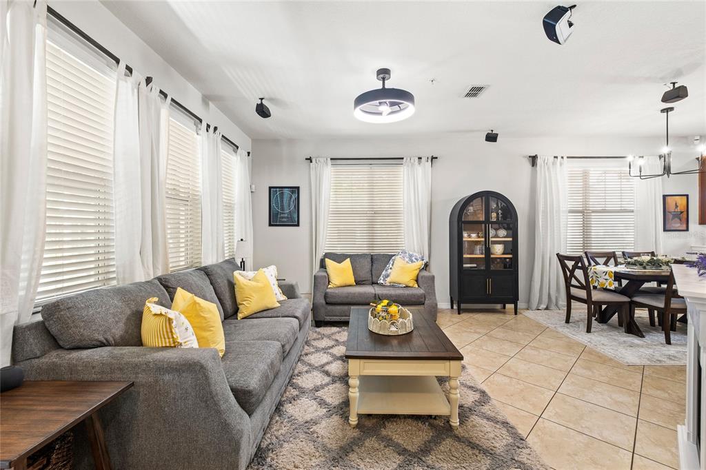 A living room features a grey sofa, a coffee table, and an adjacent dining area — 7951 NORTHLAKE PARKWAY, ORLANDO, FL
