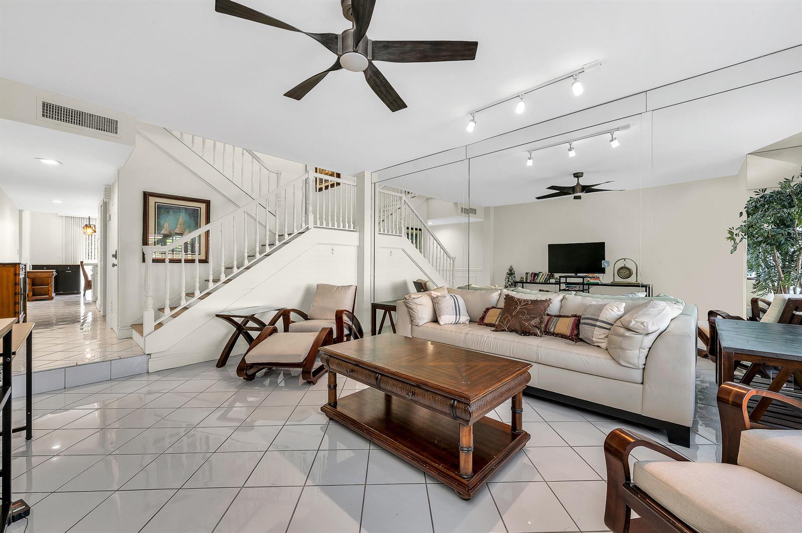 A living room features a white sofa, wooden coffee table, tiled floors, and mirrored walls — 584 SE 20th Avenue # 2, Deerfield Beach FL 33441, DEERFIELD BEACH, FL