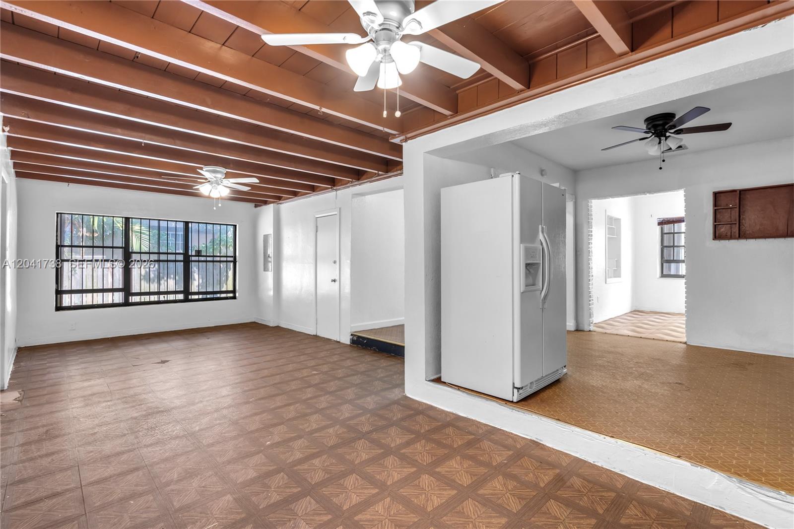 An interior view shows a living area with exposed wood beams and tiled flooring — 576 NW 147th St, Miami FL 33168, MIAMI, FL