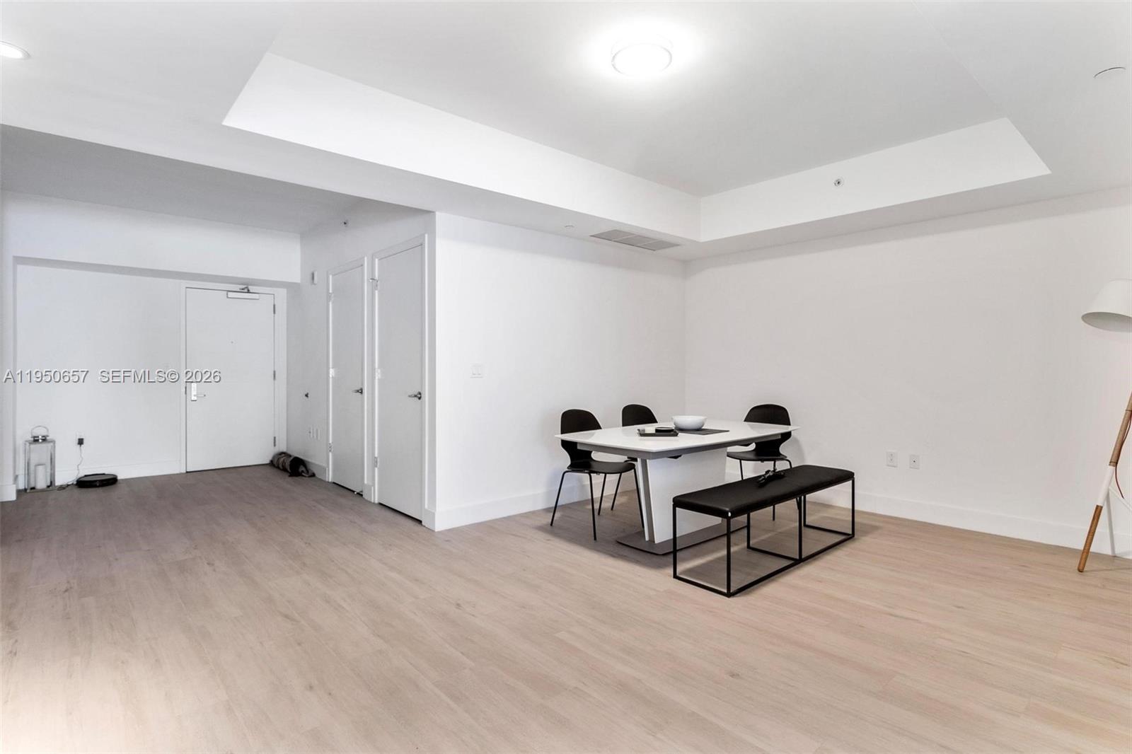 A dining area with a white table, chairs, and bench on light wood-look flooring — 1010 Brickell Ave # 1404, Miami FL 33131, MIAMI, FL
