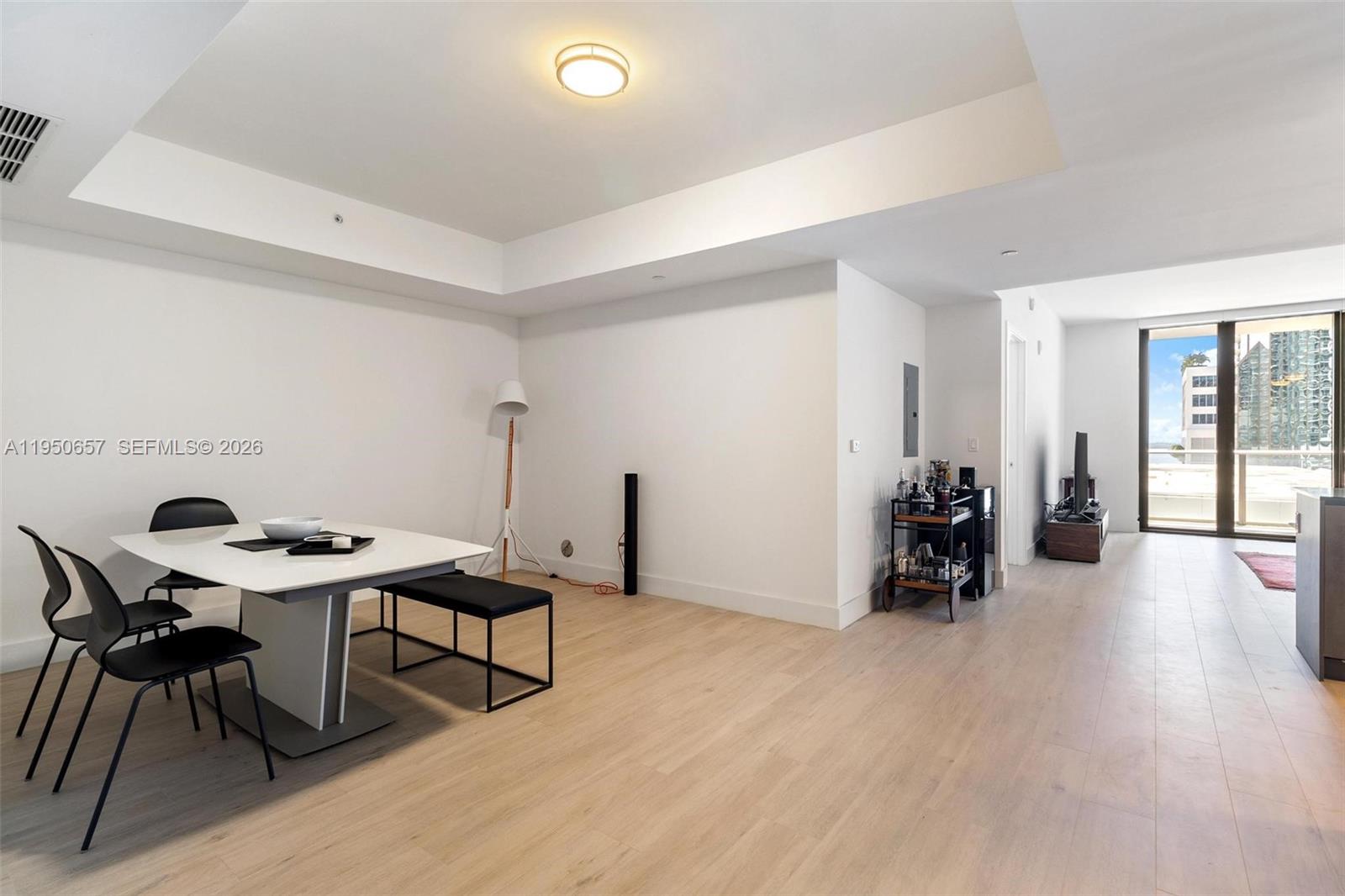A dining area with a white table and black chairs sits next to a living space — 1010 Brickell Ave # 1404, Miami FL 33131, MIAMI, FL
