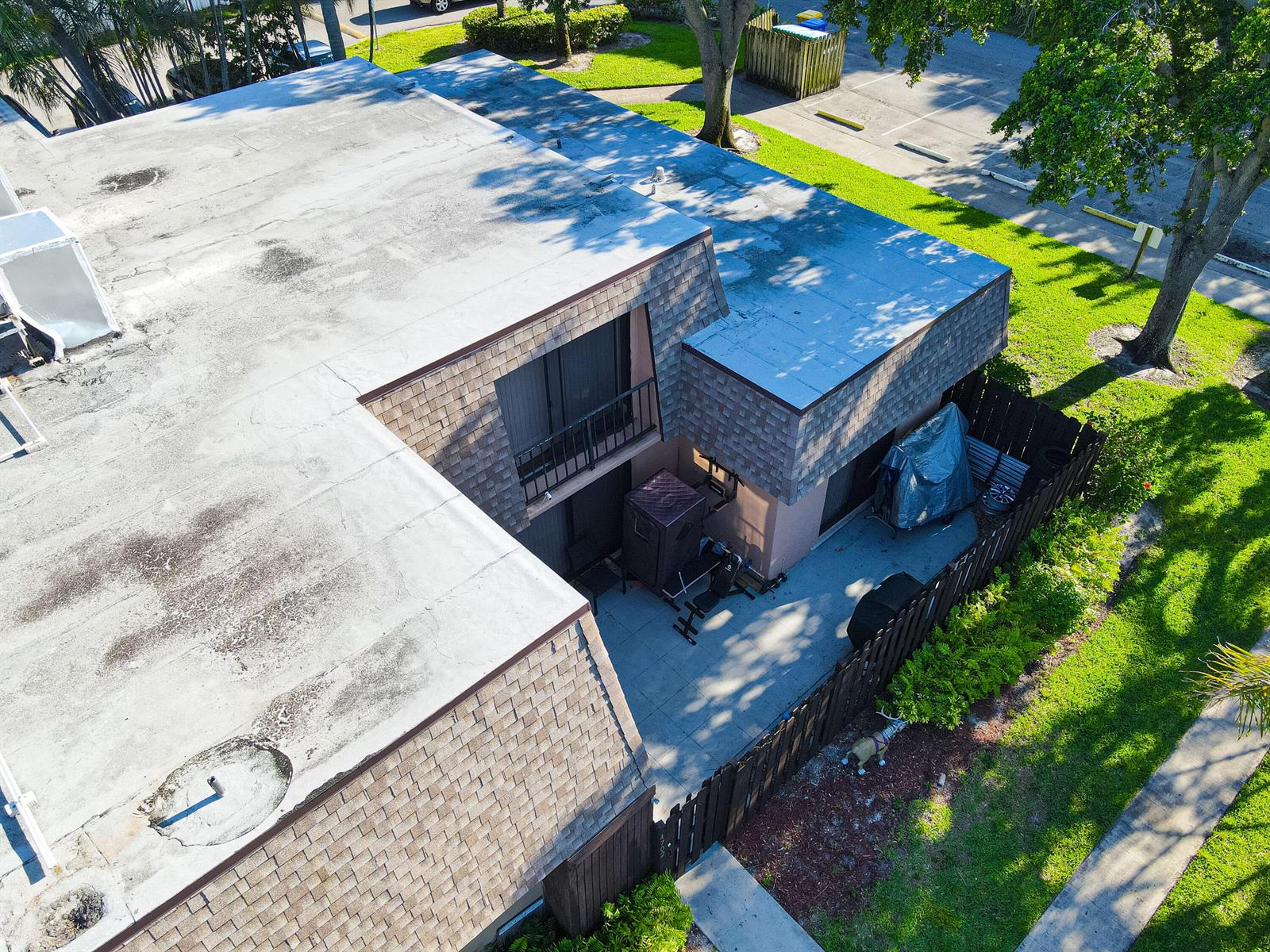 An aerial view shows the flat roof and fenced patio area of a two-story townhouse — 4702 Waterview Circle, Palm Springs FL 33461, PALM SPRINGS, FL