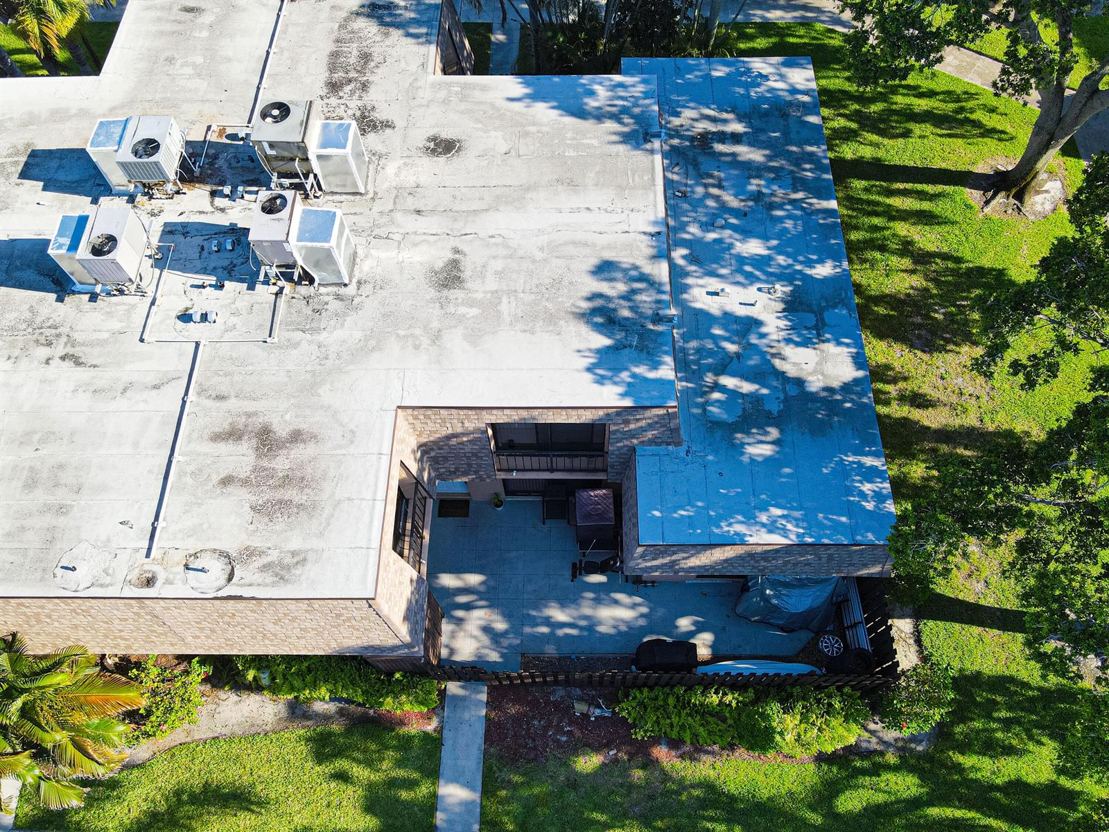 An aerial view shows the flat roof and a small ground-level patio of a building — 4702 Waterview Circle, Palm Springs FL 33461, PALM SPRINGS, FL