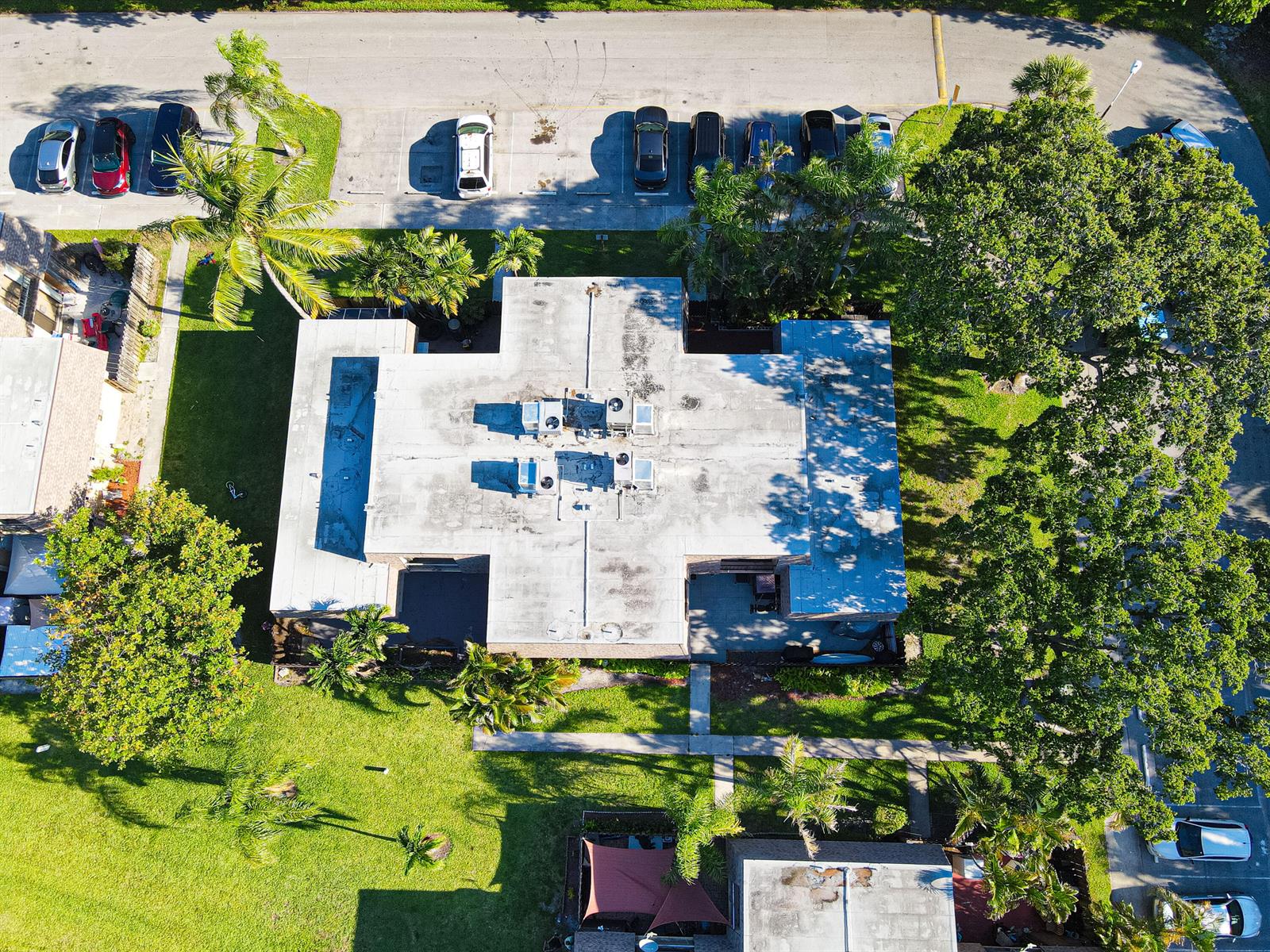 An aerial view shows a flat-roofed building surrounded by trees, parking lots, and green lawns — 4702 Waterview Circle, Palm Springs FL 33461, PALM SPRINGS, FL