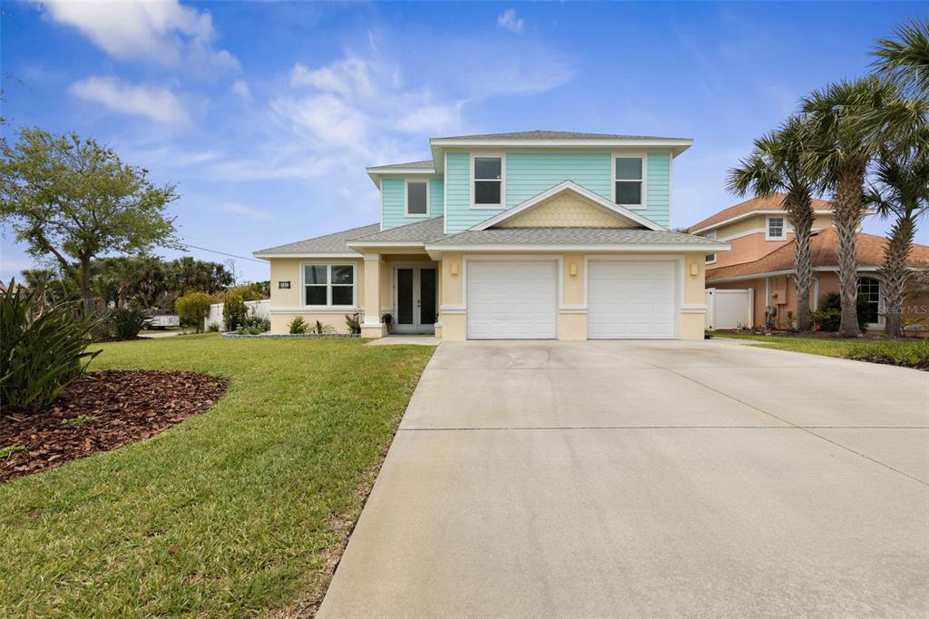 A two-story house with light blue siding, a two-car garage, and a concrete driveway — 590 SHEARWOOD DRIVE, FLAGLER BEACH, FL