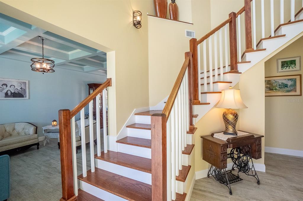 A staircase with wooden treads and white railings stands in a foyer with light walls — 590 SHEARWOOD DRIVE, FLAGLER BEACH, FL
