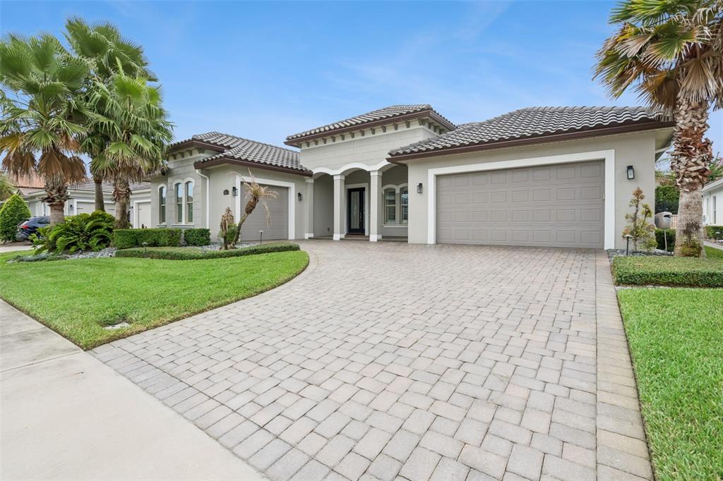A single-story house with a paved driveway, two garage doors, and palm trees in front — 1417 OIL LAMP COVE, LAKE MARY, FL