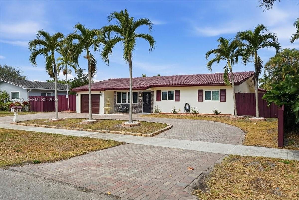 A single-story house with a brick-paved driveway, palm trees, and a maroon roof — 4925 Tyler St, Hollywood FL 33021, HOLLYWOOD, FL
