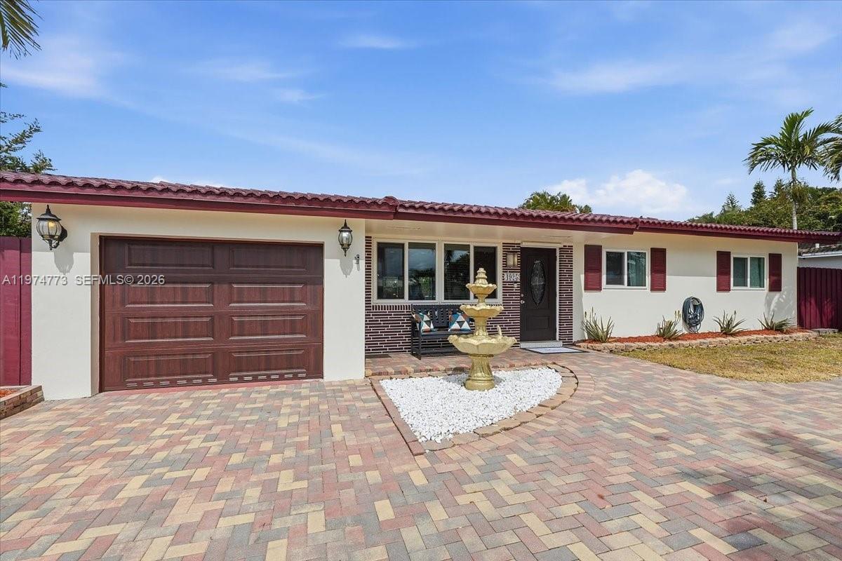 A single-story house features a brick facade, a paved driveway, and a central water fountain — 4925 Tyler St, Hollywood FL 33021, HOLLYWOOD, FL