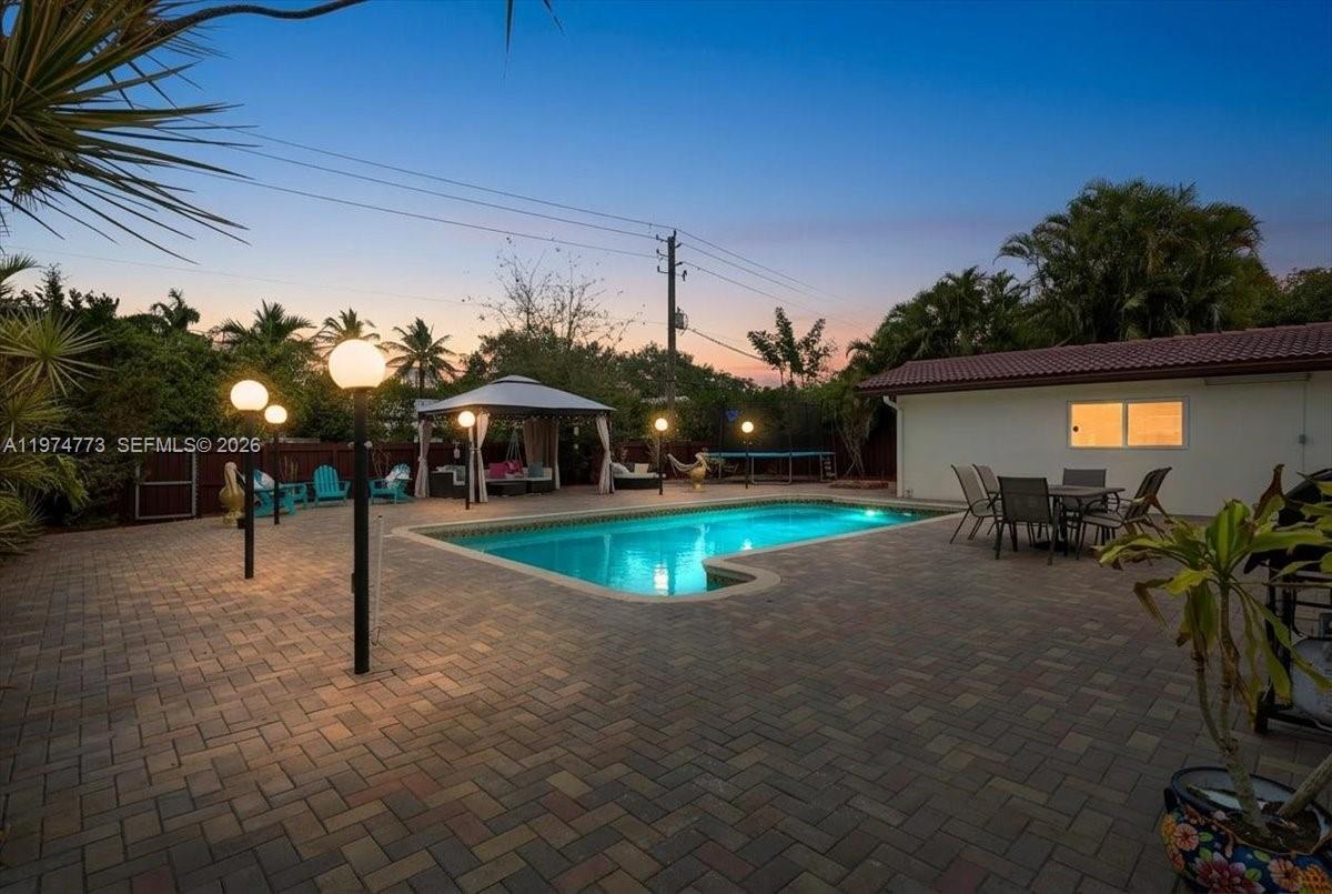 A backyard features a rectangular swimming pool, a paved patio, a gazebo, and outdoor furniture — 4925 Tyler St, Hollywood FL 33021, HOLLYWOOD, FL