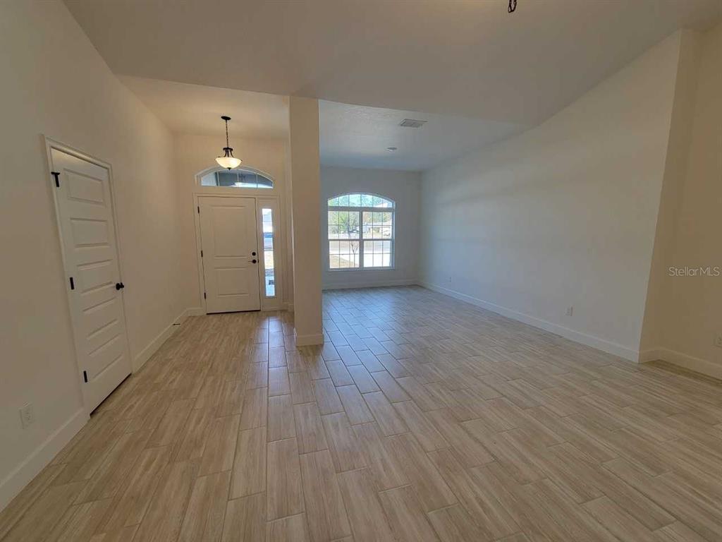 An entryway leads into a spacious living area with light-colored tile flooring and arched windows — 3121 SW 170TH PLACE, OCALA, FL