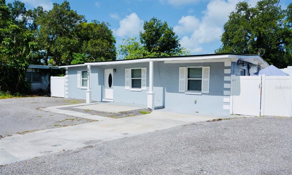 A single-story light blue house with white trim and a gravel driveway — 601 LIME TREE ROAD, TAMPA, FL