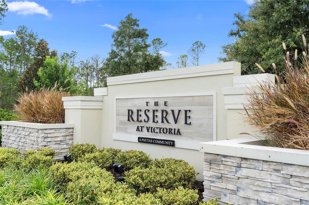 A stone and stucco monument sign for The Reserve at Victoria stands amidst landscaping — 899 MEGANO BOULEVARD, DELAND, FL