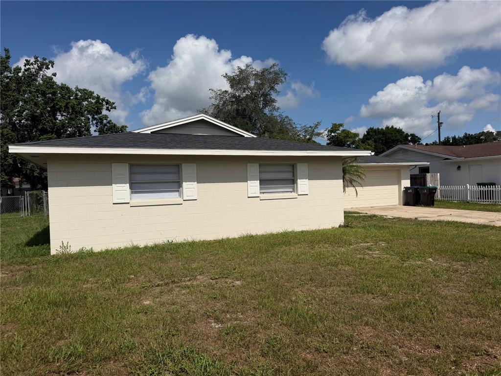 A single-story beige concrete block house with a dark shingled roof and attached garage — 4518 GASPARILLA AVENUE, ORLANDO, FL