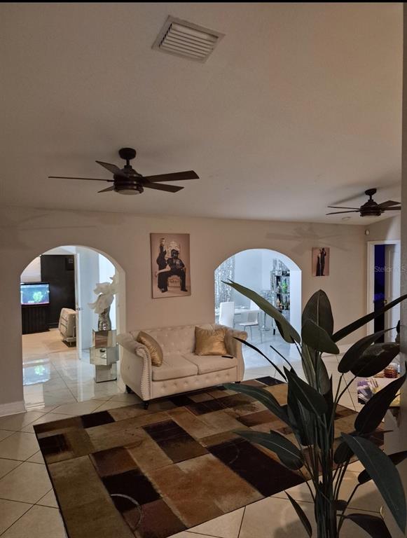 A living room features a tufted sofa, two arched doorways, and a large area rug — 4856 ARCHIE LANE, FORT MYERS, FL