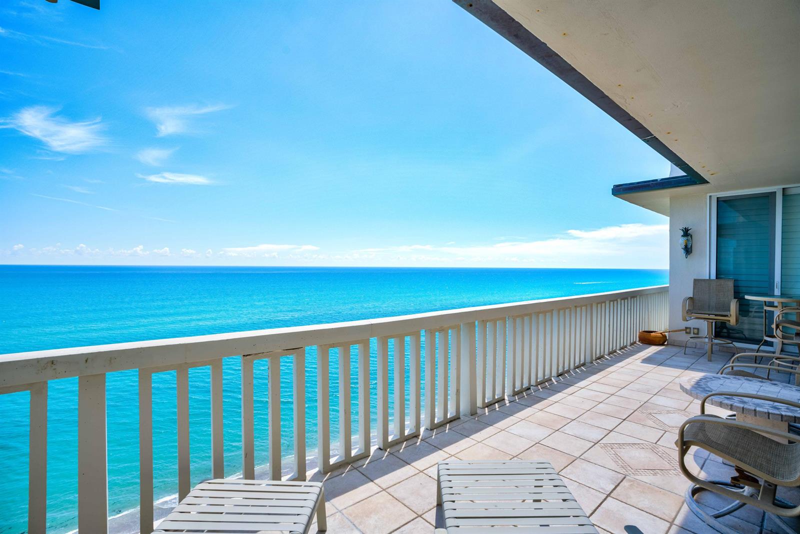 A tiled balcony overlooks the ocean with white railings and outdoor furniture — 840 Ocean Drive # c, Juno Beach FL 33408, JUNO BEACH, FL