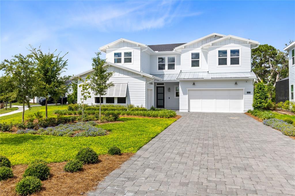 A two-story white house with horizontal siding features a paved driveway and a front lawn — 3122 VANGUARD COURT, ST CLOUD, FL
