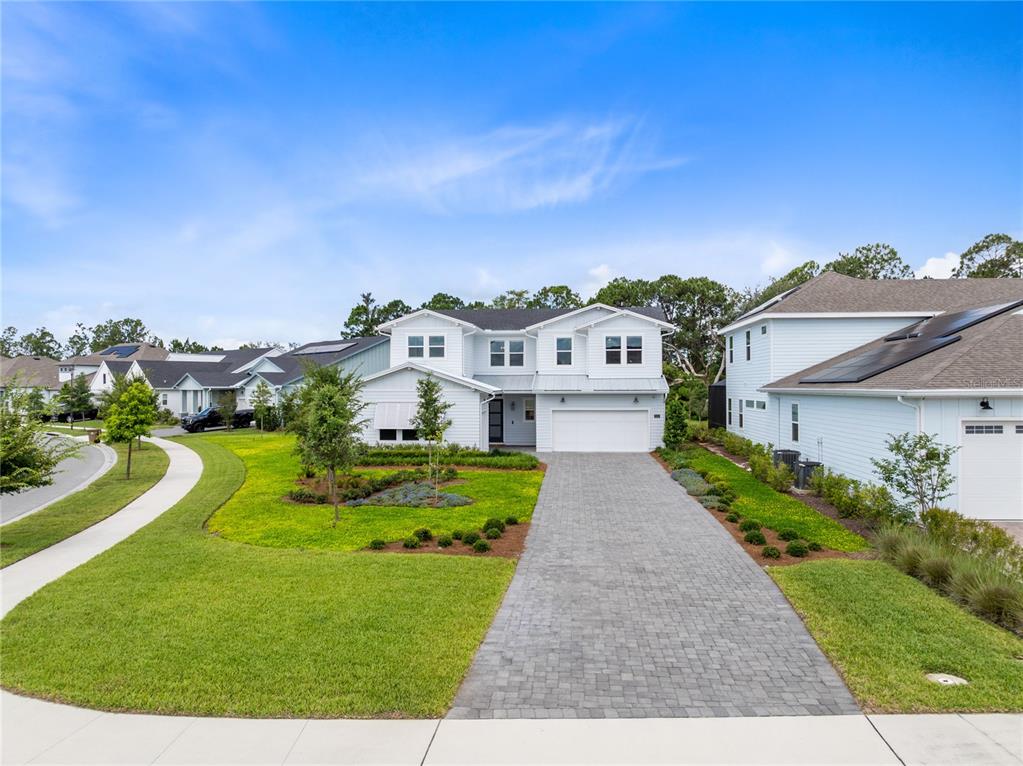A two-story white house with a paved driveway and a landscaped front yard — 3122 VANGUARD COURT, ST CLOUD, FL