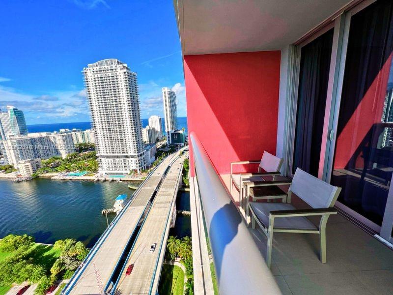 A balcony with two chairs overlooks a bridge, a waterway, and high-rise buildings — 2602 E Hallandale Beach # 2008A, Hallandale Beach FL 33009, HALLANDALE BEACH, FL