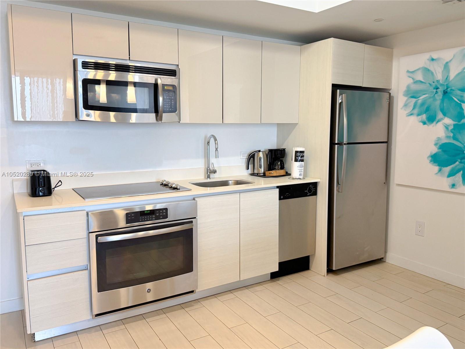 A modern kitchen features stainless steel appliances, light wood cabinetry, and a white countertop — 2602 E Hallandale Beach # 2008A, Hallandale Beach FL 33009, HALLANDALE BEACH, FL