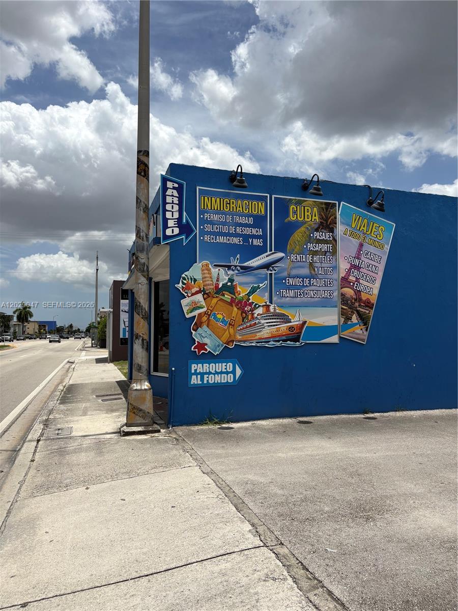 A blue building exterior features signage for immigration services and travel agency offerings — 6620 W Flagler St, Miami FL 33144, MIAMI, FL