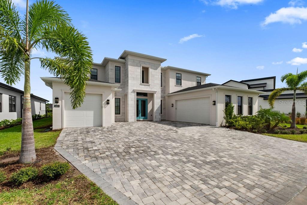 A two-story house features a stone-accented entryway with bright blue double doors and a driveway — 9453 GOLDEN LAUREL LANE, ORLANDO, FL