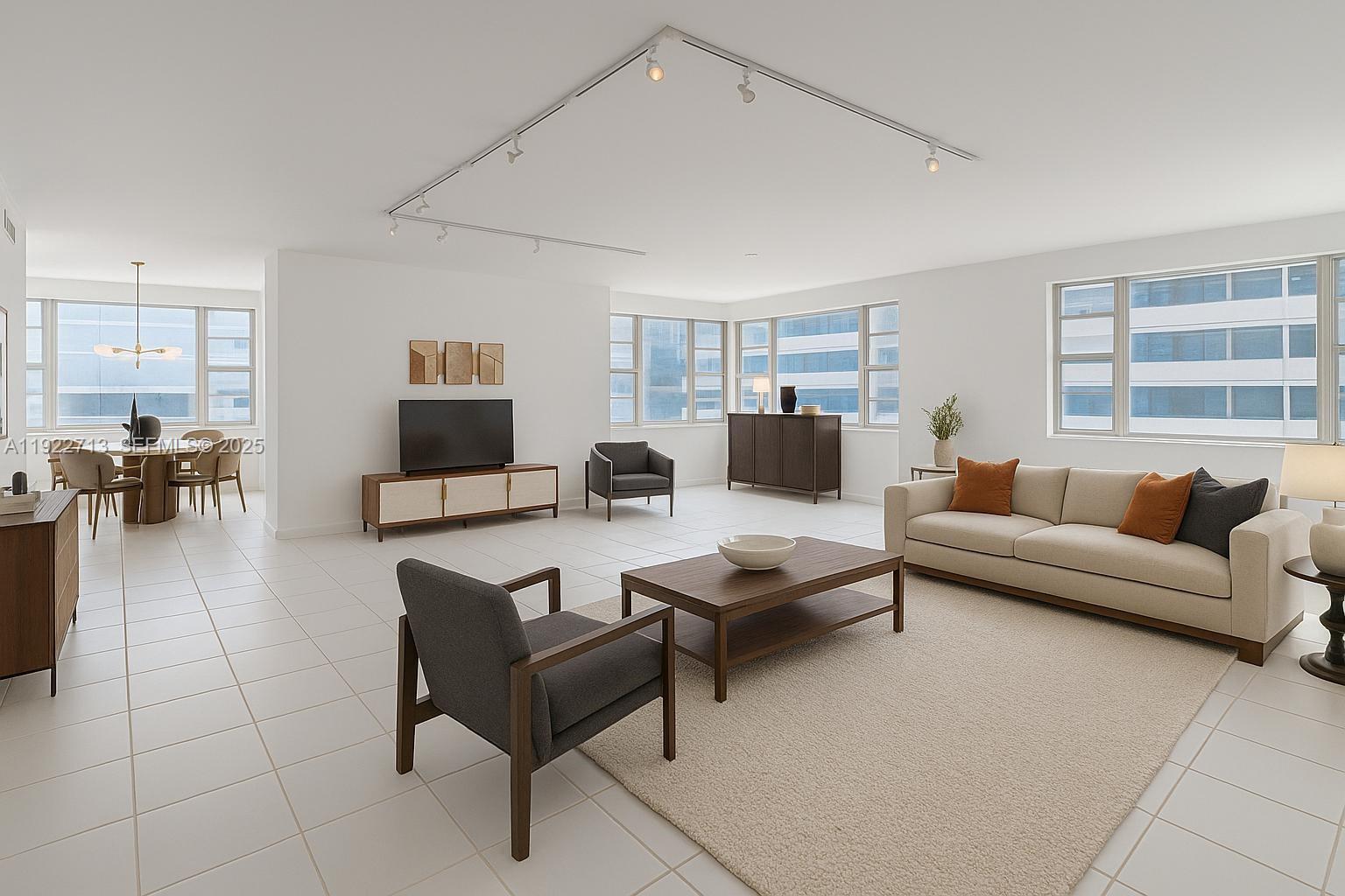 A bright, open-concept living and dining area features white tile floors and large windows — 5255 Collins Ave # 5D, Miami Beach FL 33140, MIAMI BEACH, FL