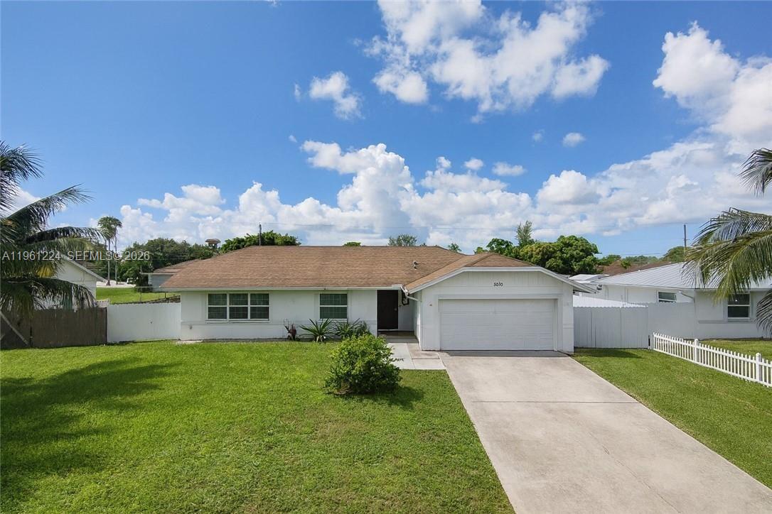 A single-story white house with a brown roof, a garage, and a front lawn — 5010 SW 31st AVE, Naples FL 34116, NAPLES, FL