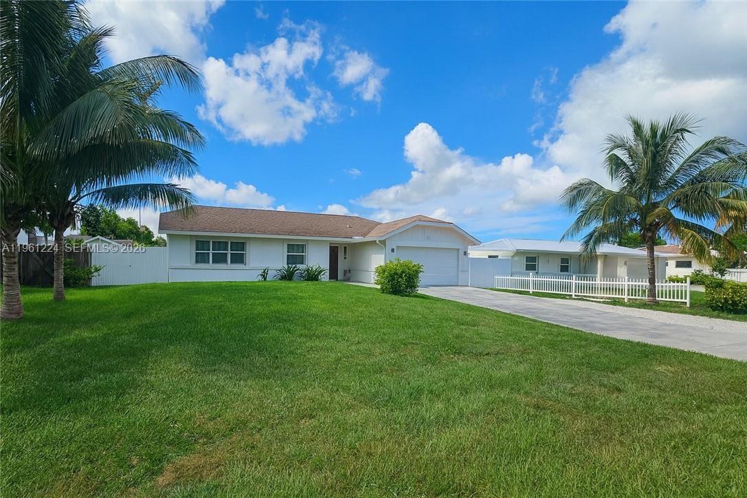 A single-story house with a white exterior, a brown roof, and a large front lawn — 5010 SW 31st AVE, Naples FL 34116, NAPLES, FL
