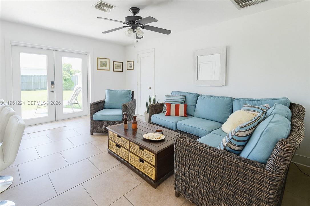 A living room features wicker furniture, a coffee table with baskets, and glass patio doors — 5010 SW 31st AVE, Naples FL 34116, NAPLES, FL