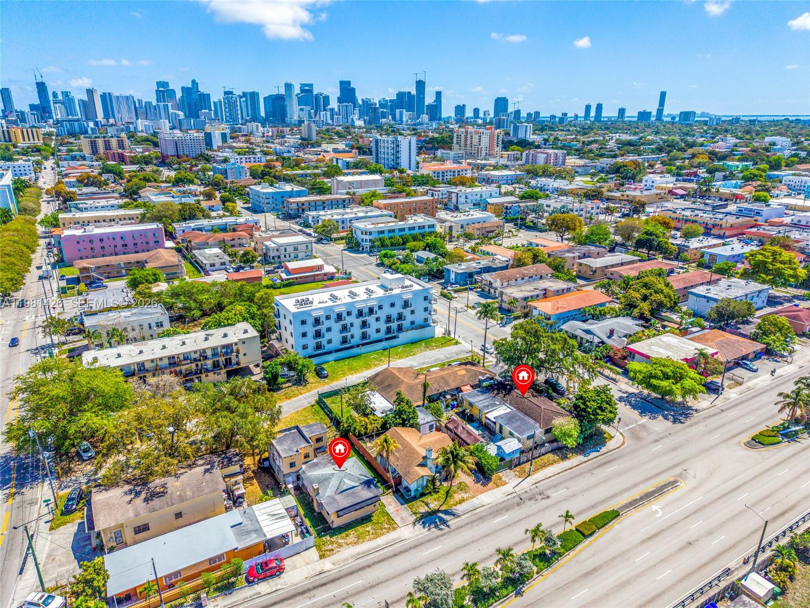An aerial view shows two adjacent houses with red location markers against a city skyline — 1675 NW 2nd St, Miami FL 33125, MIAMI, FL