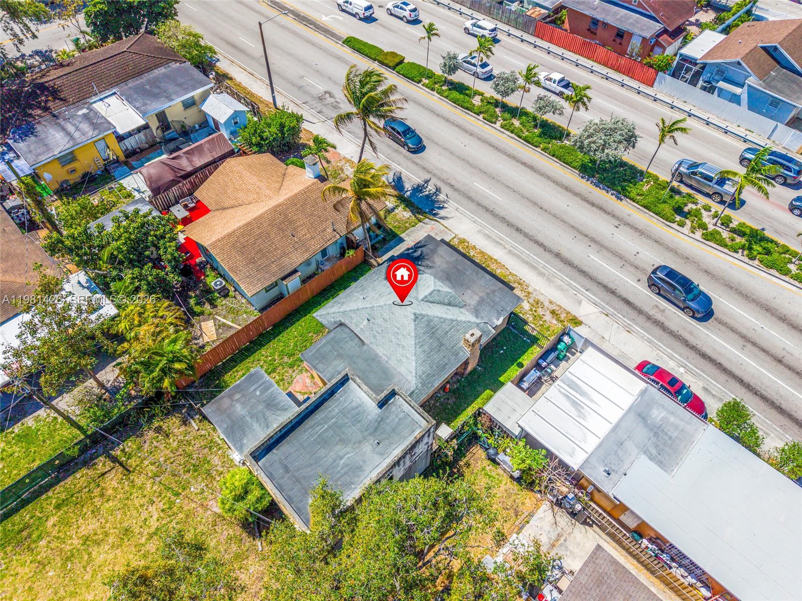 An aerial view shows a residential house with a red location pin on its roof — 1675 NW 2nd St, Miami FL 33125, MIAMI, FL
