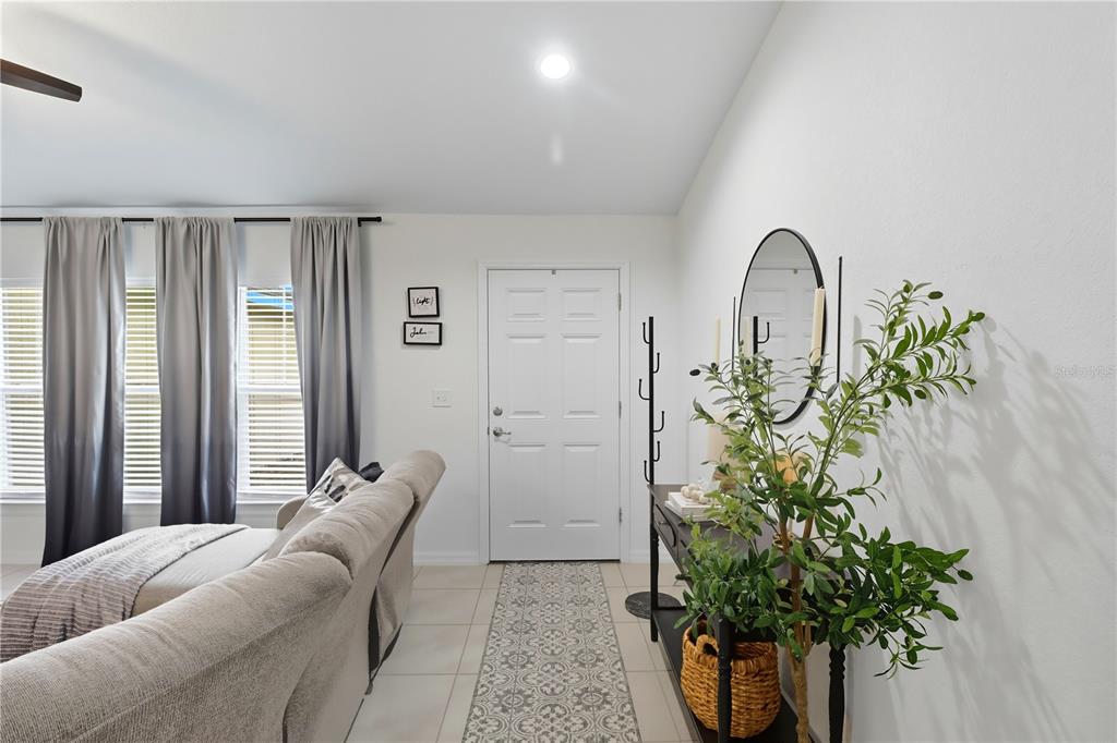 An entryway features a white door, a console table with a plant, and tile flooring — 6651 SW 151ST LOOP, OCALA, FL