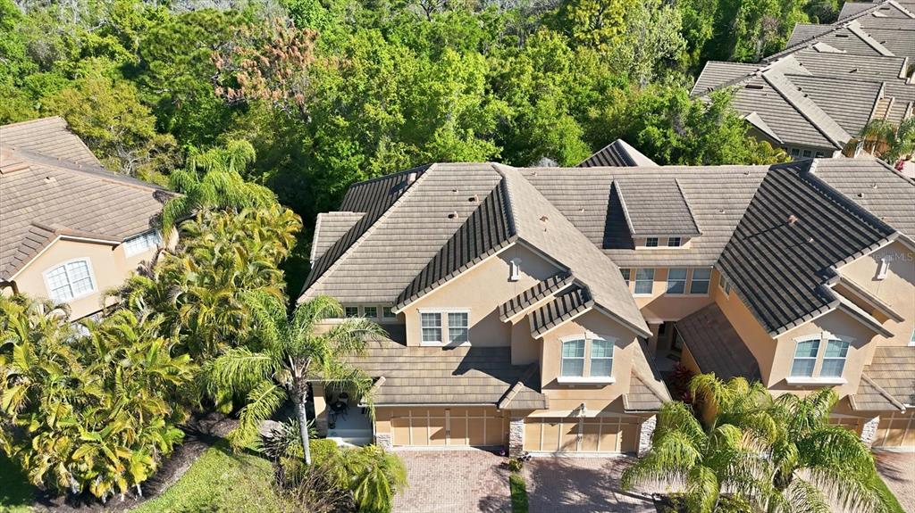An aerial view shows a multi-story tan townhouse with a brown tile roof — 5427 NAPA DRIVE, SARASOTA, FL