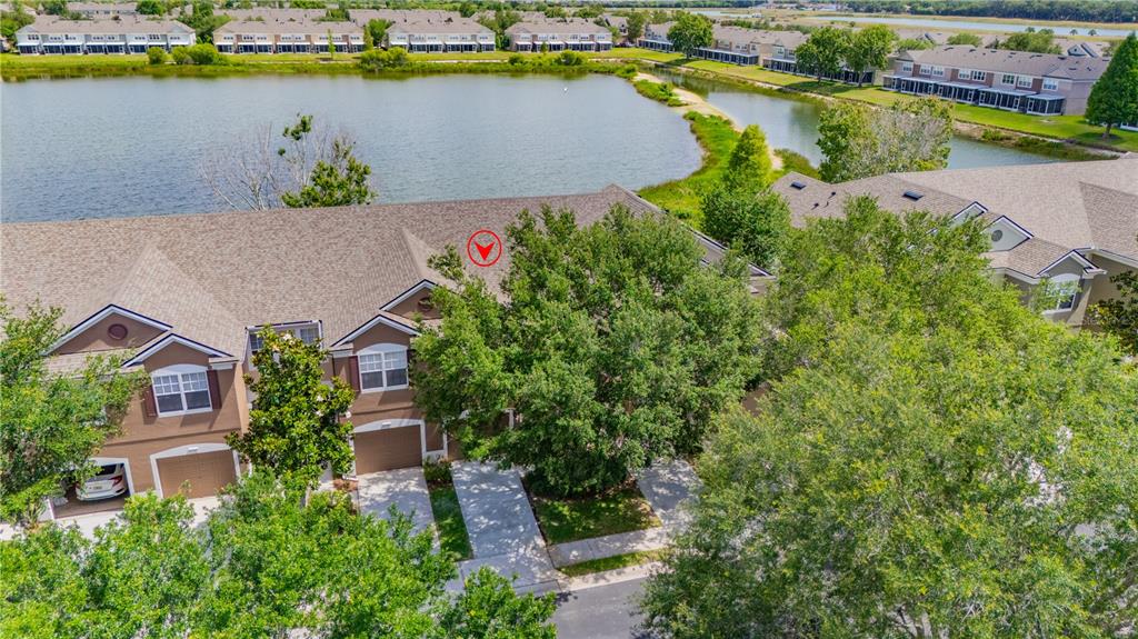 An aerial view shows a residential townhouse complex situated next to a large lake — 4939 POND RIDGE DRIVE, RIVERVIEW, FL